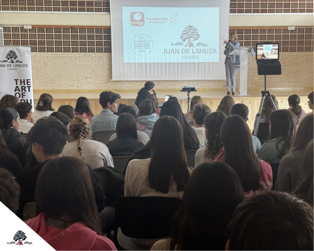 Acto institucional del Colegio Juan de Lanuza para celebrar los premios de innovación educativa, con alumnado y profesorado asistiendo a una ponencia en el salón de actos.