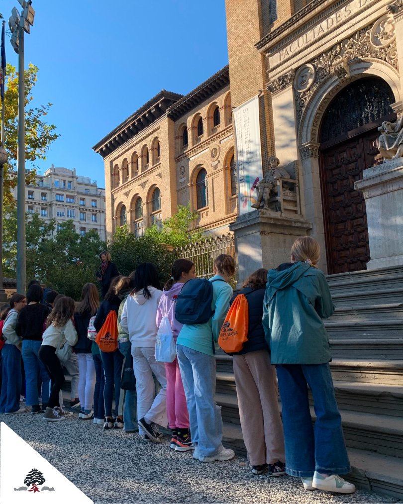 Alumnado de 6º de Primaria del Colegio Juan de Lanuza observa un edificio histórico durante una ruta matemática por el centro de Zaragoza.