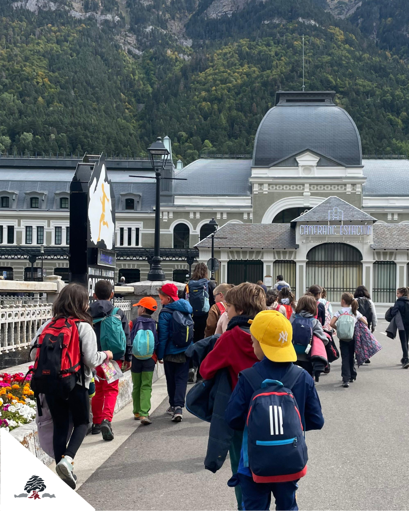 Grupo de alumnos del Colegio Juan de Lanuza caminando por Canfranc frente a la estación internacional durante una salida educativa en la naturaleza.
