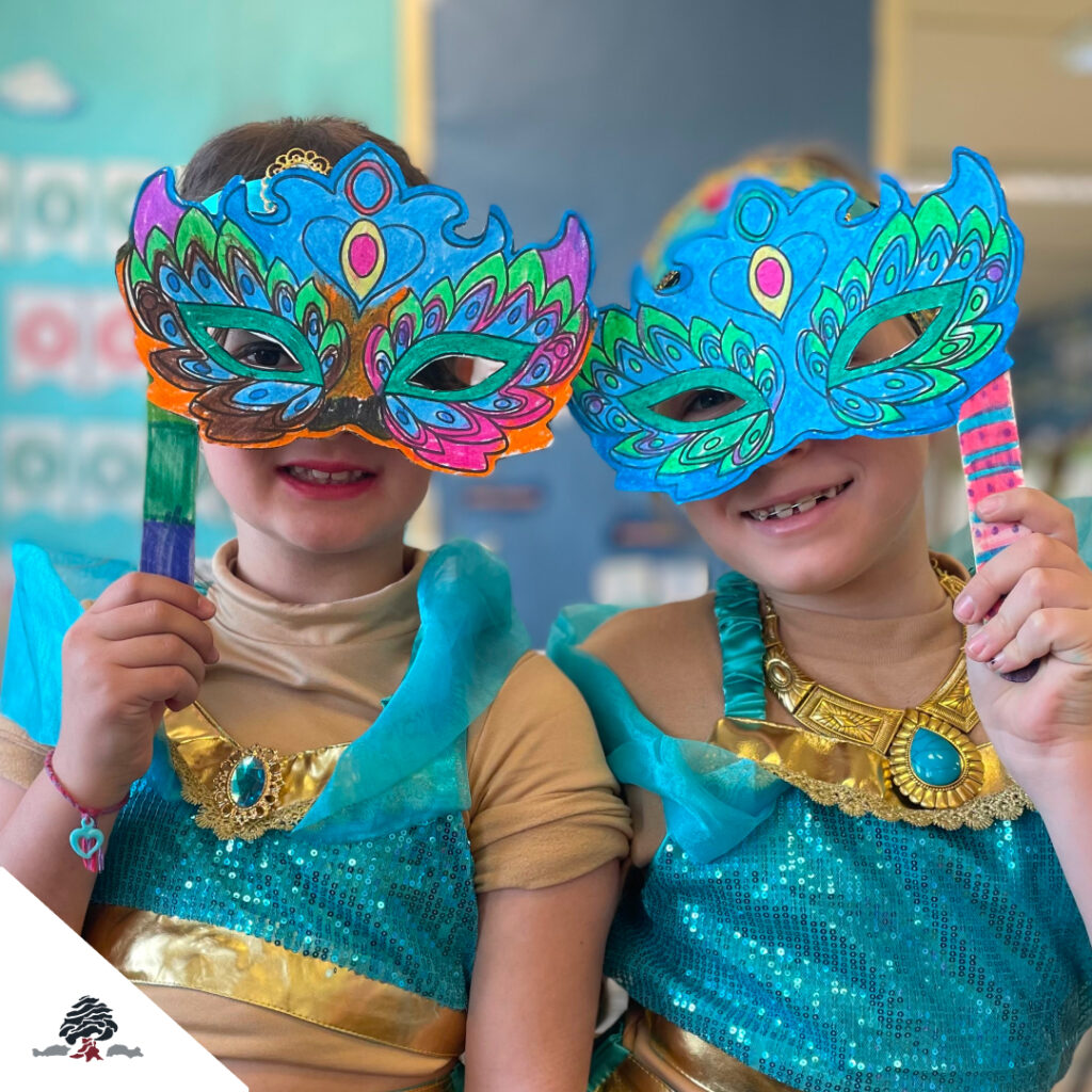 Dos alumnas del Colegio Juan de Lanuza posan con máscaras coloridas durante la celebración de Carnaval.