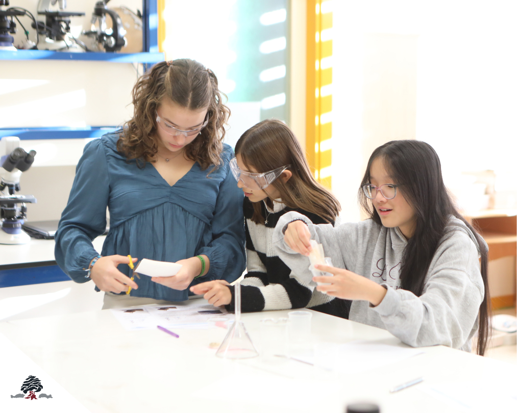 Tres alumnas trabajando en el laboratorio de ciencias del Colegio Juan de Lanuza, realizando un experimento con material de química y utilizando gafas de protección.